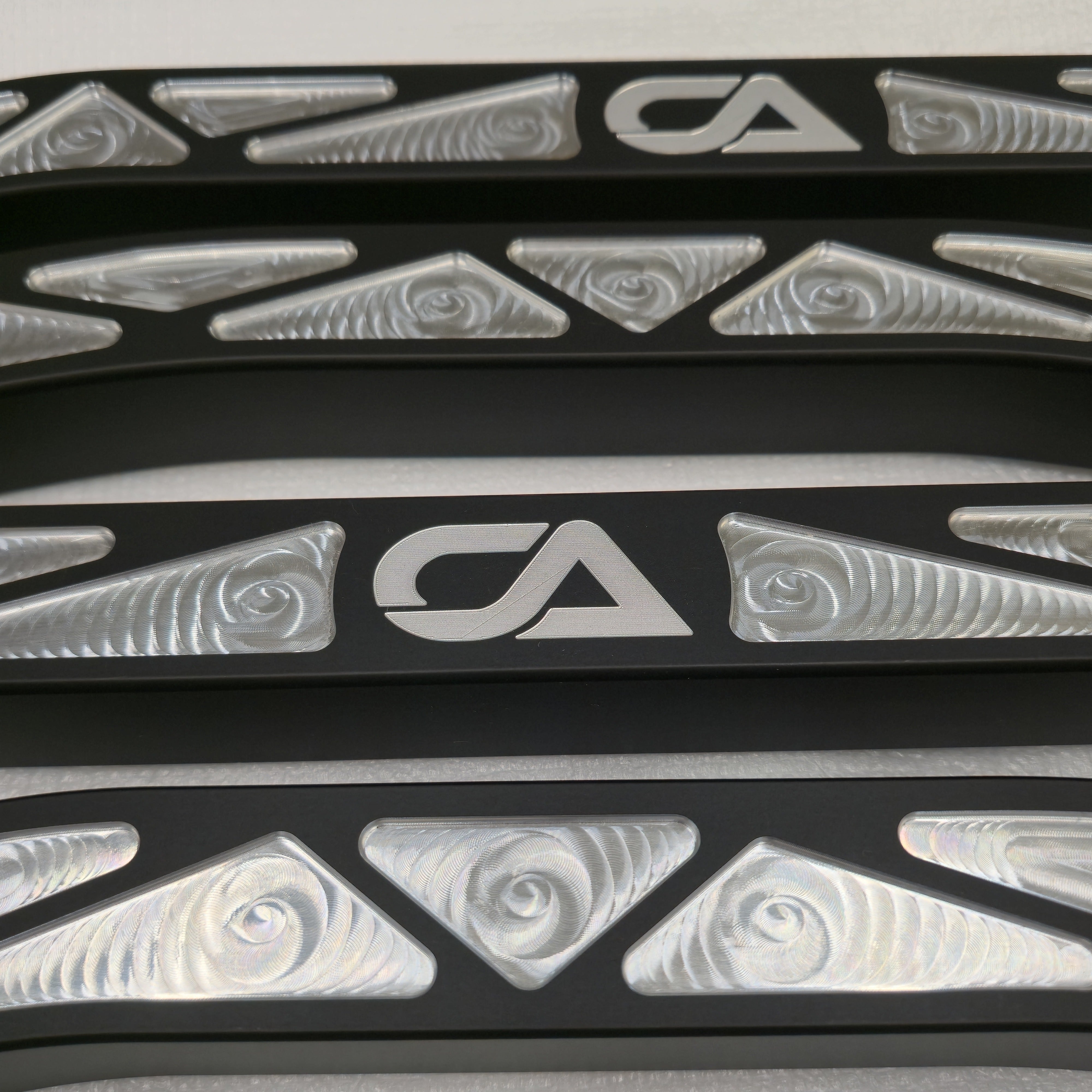 Close-up of CA Technologies logo and machined pockets on black radius rods